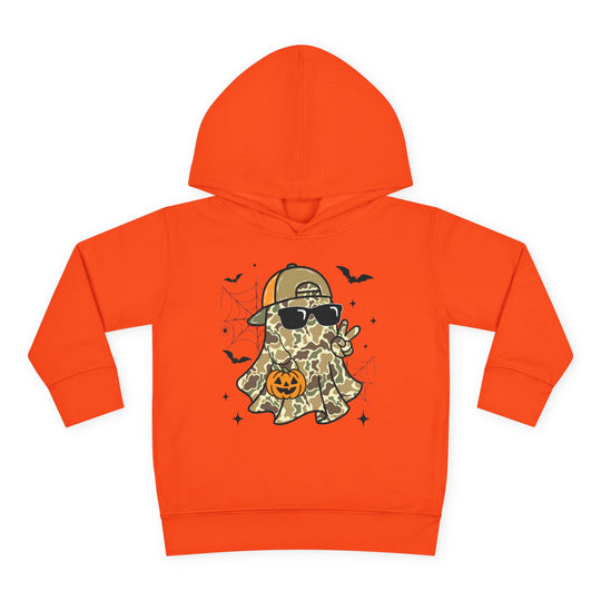 Candy Ghost Toddler Hoodie features a playful camouflage ghost with a cap, sunglasses, peace sign, and jack-o’-lantern, surrounded by bats and webs.