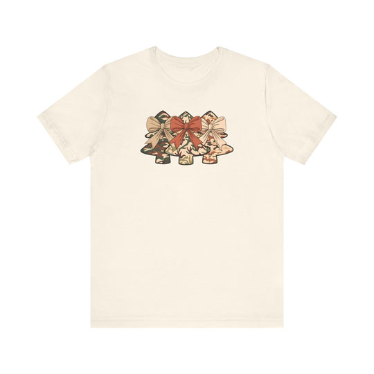 Camo Christmas Tree Tee: Light-cream T-shirt featuring three stylized Christmas trees with camouflage patterns and bows, offering a soft, comfortable fit in various sizes.