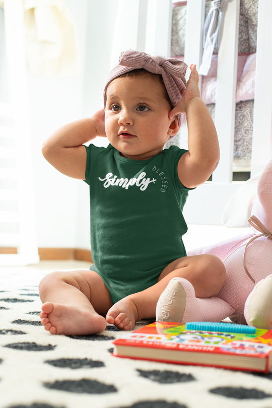 Simply Blessed Onesie on a baby, showcasing its soft, ring-spun cotton fabric. The bodysuit features lap shoulders for easy dressing, ideal for infants.