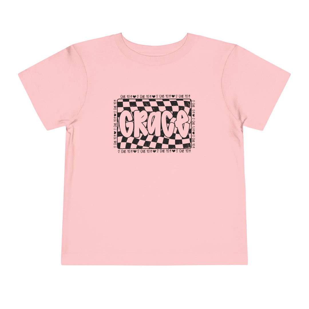 Grace Toddler Tee featuring a playful black and white text design on a pink shirt, perfect for kids' everyday comfort with its soft cotton fabric.