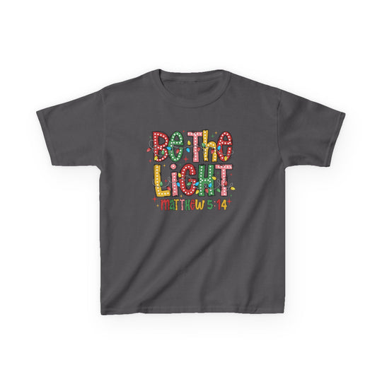 Dark-gray kids' T-shirt with Be The Light in colorful letters and holiday lights, referencing Matthew 5:14; durable, soft 100% cotton fabric.