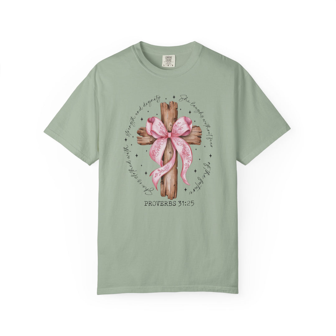Proverbs 31:25 Tee features a rustic wooden cross with a pink ribbon and verse, offering strength and dignity in sage-green Comfort Colors fabric.