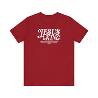 Jesus is King Tee featuring white text on a soft red fabric, classic unisex fit with ribbed knit collars, perfect for a comfortable, stylish look.