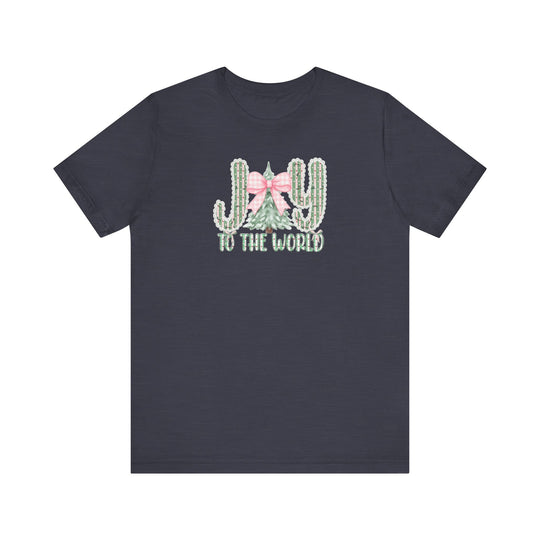 Joy to the World Tee: Dark-navy T-shirt featuring JOY with cacti and Christmas tree graphic, pink gingham bow, and TO THE WORLD text. Soft, unisex fit.