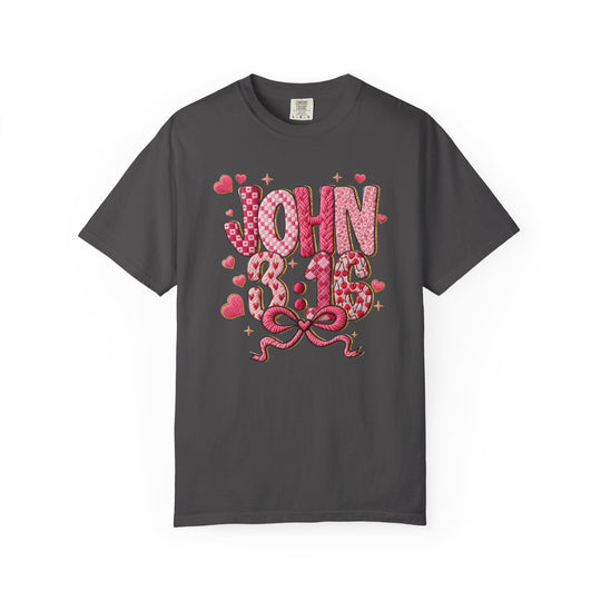 3:16 Tee featuring JOHN 3:16 in pink heart-patterned letters, with scattered hearts and starbursts, and a pink ribbon detail on a dark-charcoal background.