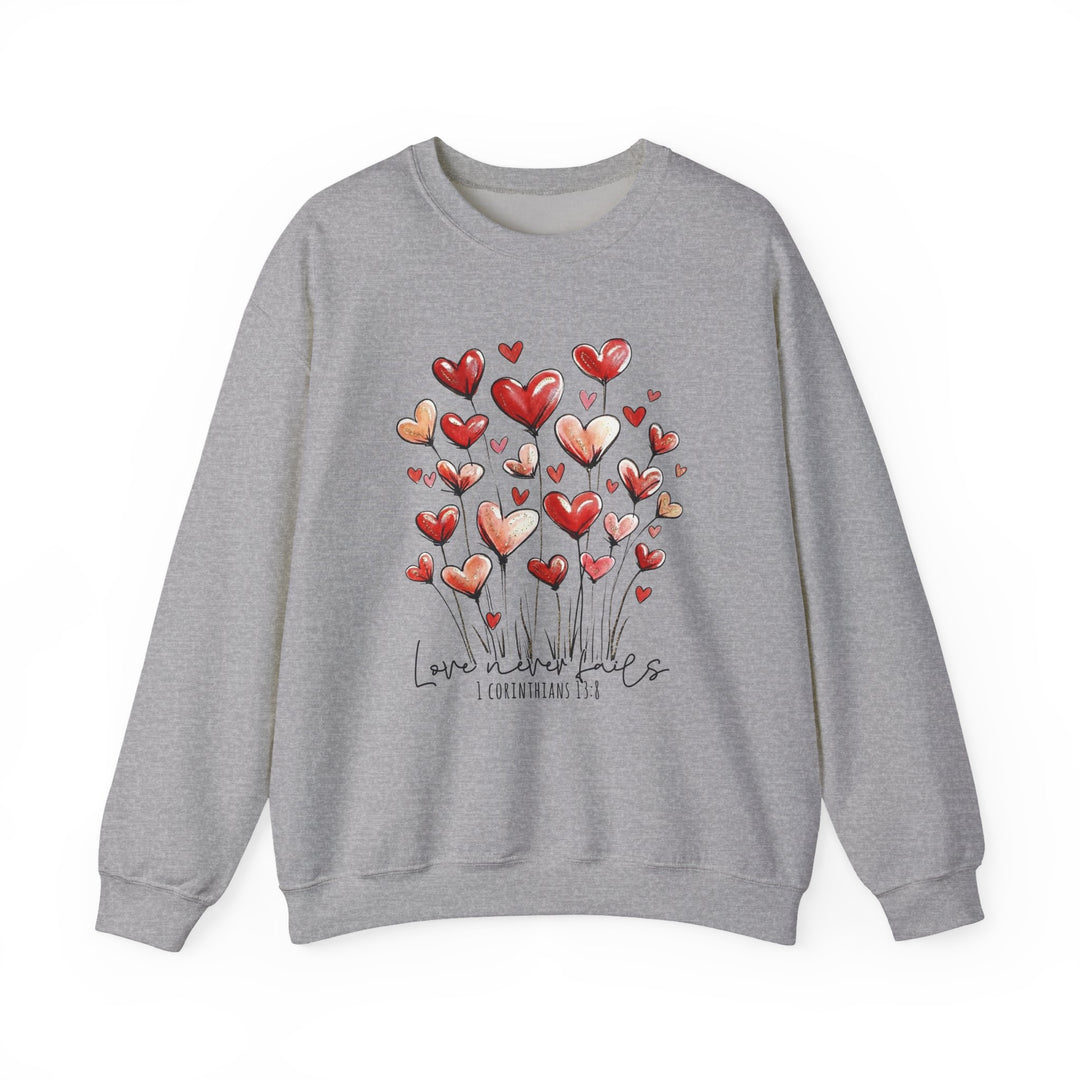 Love Never Fails Crew sweatshirt features heart-shaped blooms and Love never fails text, combining comfort with meaningful design, ideal for all occasions.