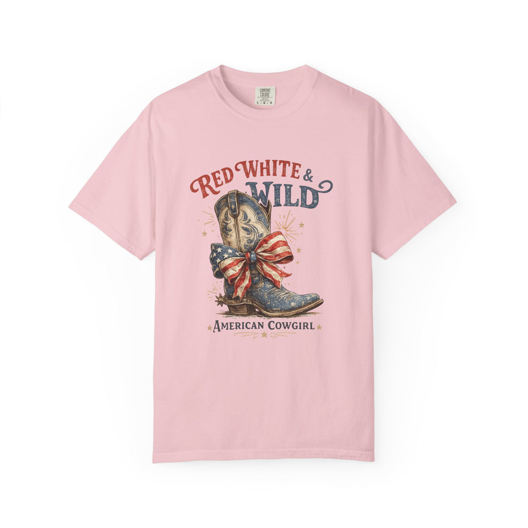 Pastel-pink tee with cowboy boot and American flag bow, Red White & Wild text, perfect for casual, patriotic wear. Sizes S-4XL.