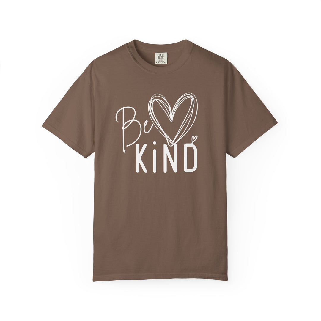 Be Kind Tee with a white graphic, featuring a scribble heart between Be and Kind, on a brown, short-sleeve crew-neck T-shirt by Comfort Colors.
