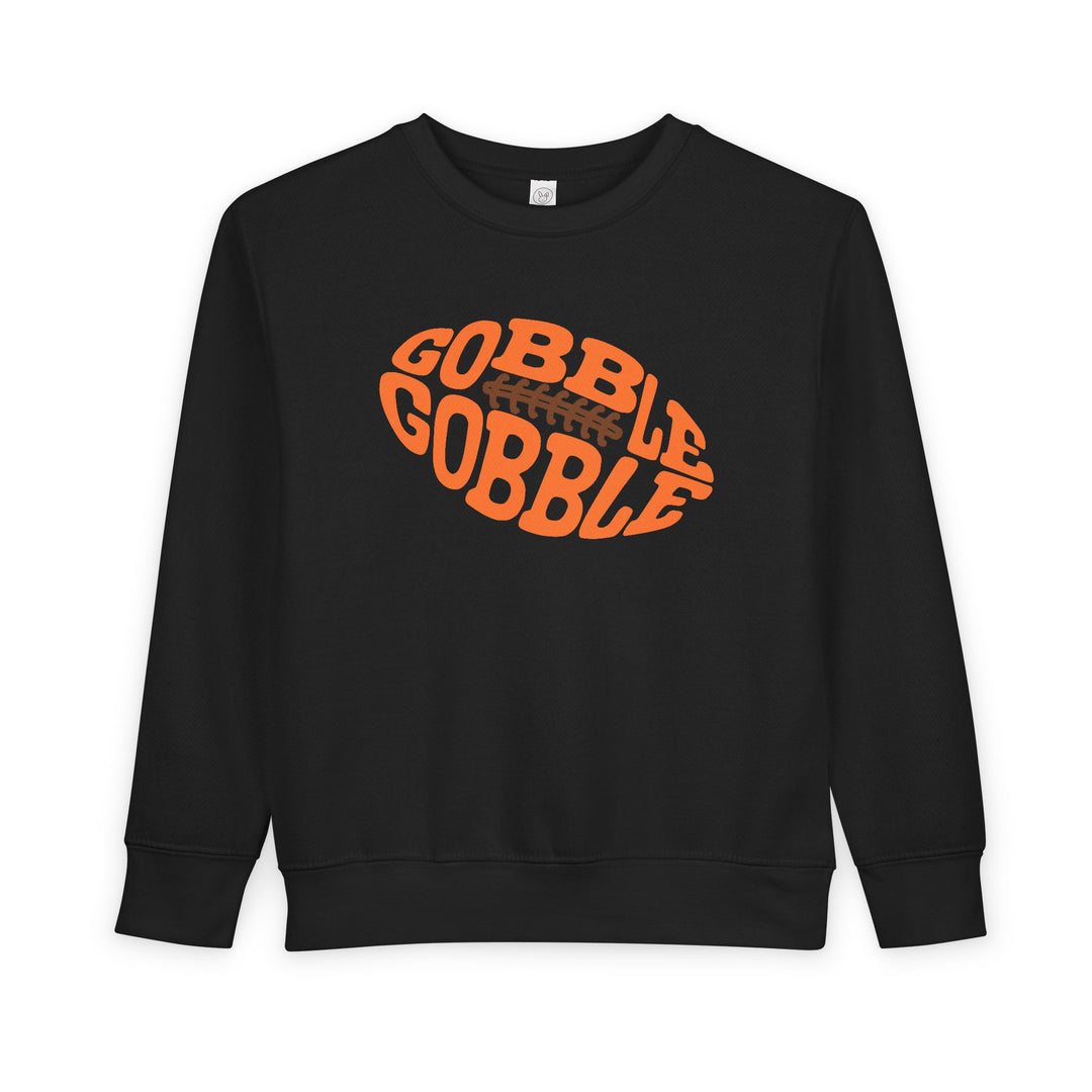 Gobble Football Toddler Crew: Black sweatshirt with GOBBLE GOBBLE graphic in an orange football shape, offering warmth and comfort for toddlers.