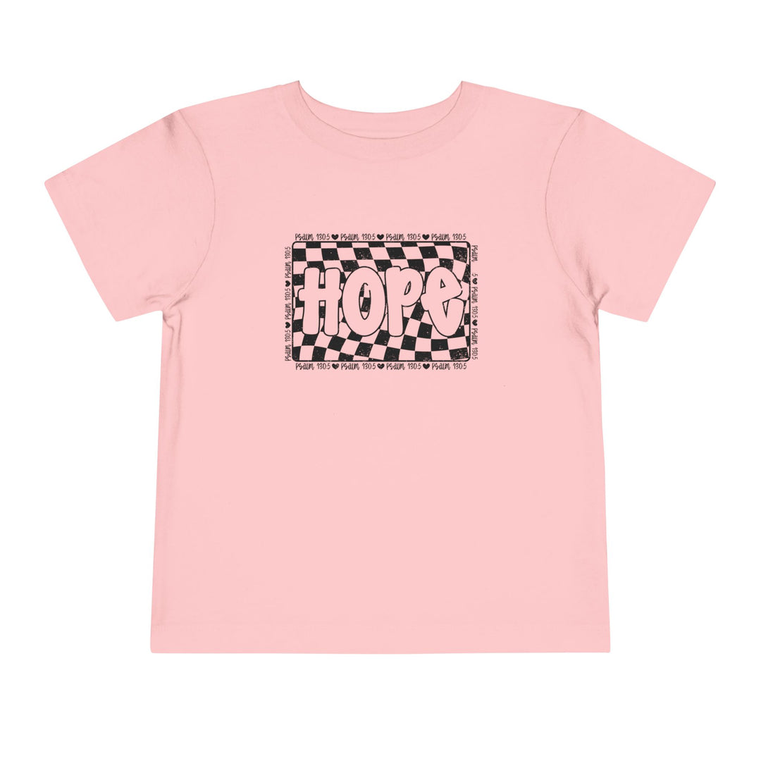 The Hope Toddler Tee features a playful black and white design on a pink shirt, perfect for adding a unique touch to any toddler's wardrobe.