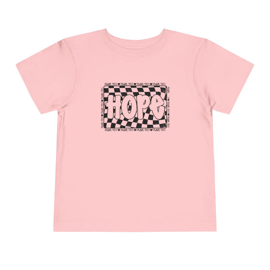 The Hope Toddler Tee features a playful black and white design on a pink shirt, perfect for adding a unique touch to any toddler's wardrobe.
