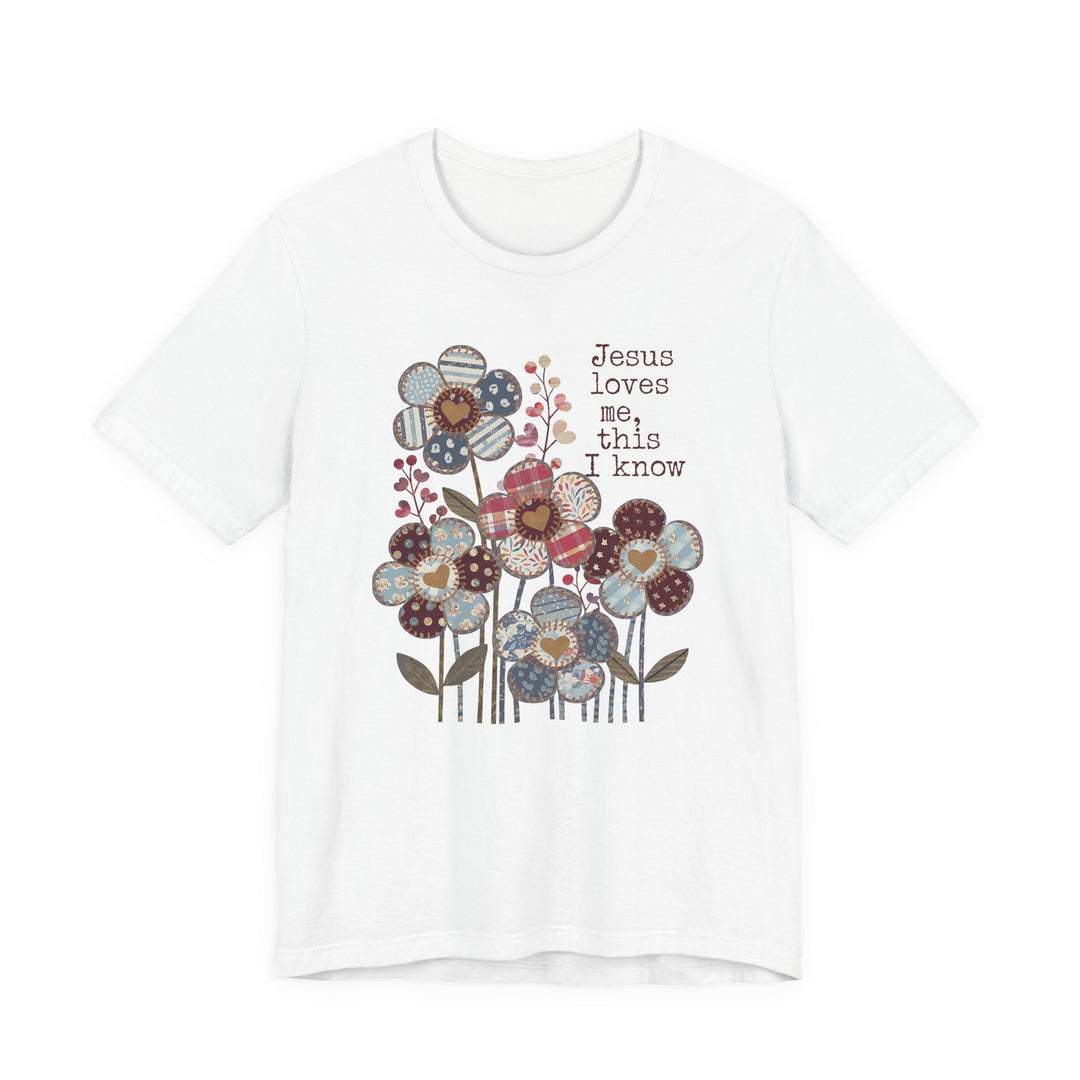 Jesus Loves Me Tee with patchwork-style floral design and heartfelt text, crafted from soft cotton for a comfortable fit, suitable for all genders.