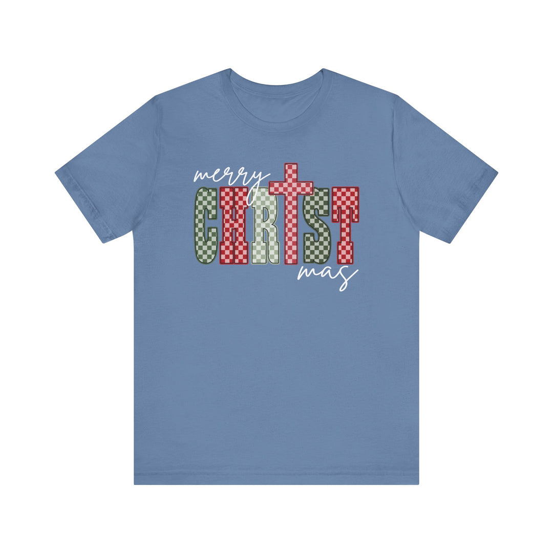 Light-blue Christmas Tee with “Merry Christmas” graphic, featuring bold, checkerboard “CHRIST” lettering. Soft cotton, unisex fit, ribbed knit collar, sizes XS-3XL available.
