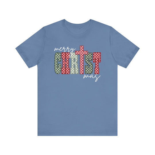Light-blue Christmas Tee with “Merry Christmas” graphic, featuring bold, checkerboard “CHRIST” lettering. Soft cotton, unisex fit, ribbed knit collar, sizes XS-3XL available.