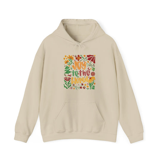 Light-cream hoodie with Joy to the World graphic featuring flowers, holly, and Christmas motifs, offering warmth and style for cold days.