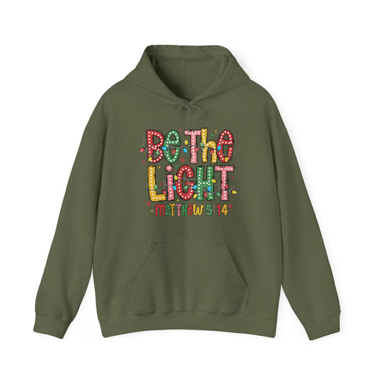 Unisex olive-green hoodie with Be the Light graphic and Bible verse Matthew 5:14. Features drawstring hood, kangaroo pocket, combines cotton-polyester for warmth.