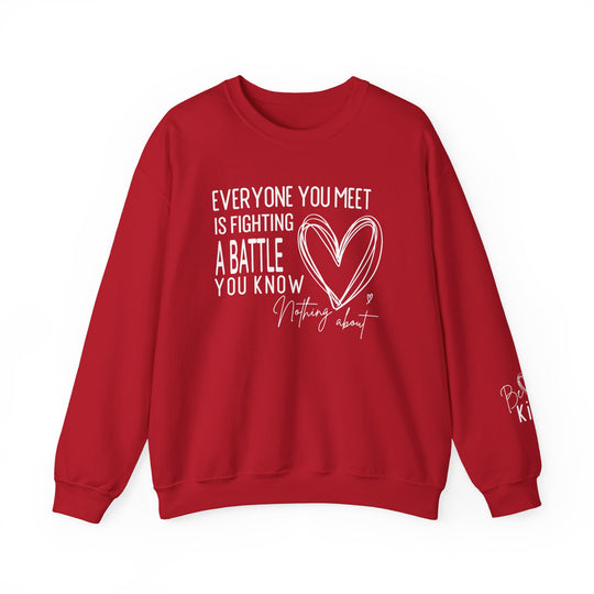 Red crewneck sweatshirt with motivational text Everyone you meet is fighting a battle you know nothing about and Be kind message on sleeve, designed by Faith Family Designs.