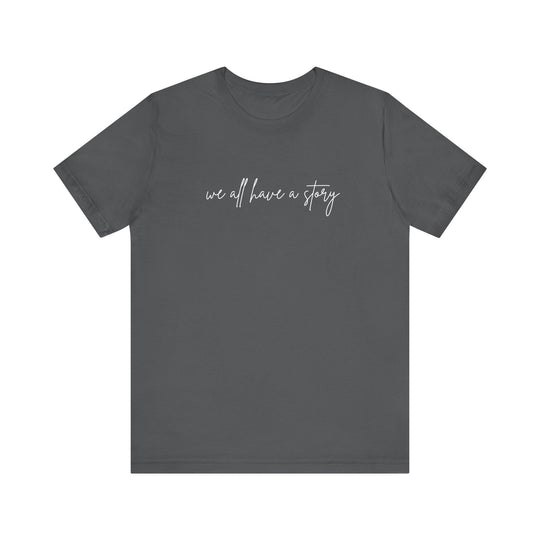 We all have a Story Tee: Grey t-shirt with white text, classic unisex fit, soft cotton fabric, ideal for casual or semi-formal wear.