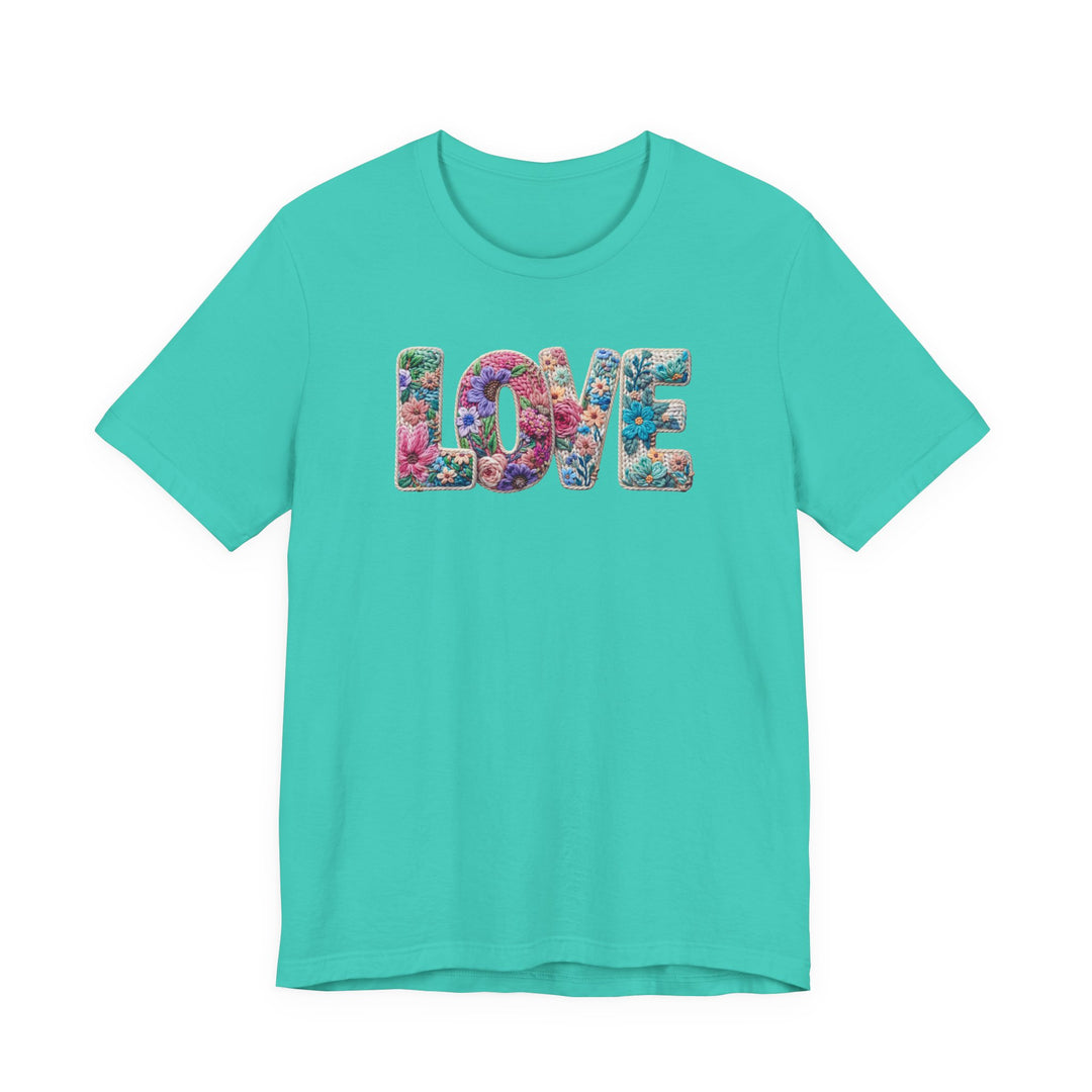 Love Spring Tee featuring LOVE with multicolored floral pattern on bright teal, short-sleeve, cotton shirt, unisex fit, reflecting Faith Family Designs' unique style.