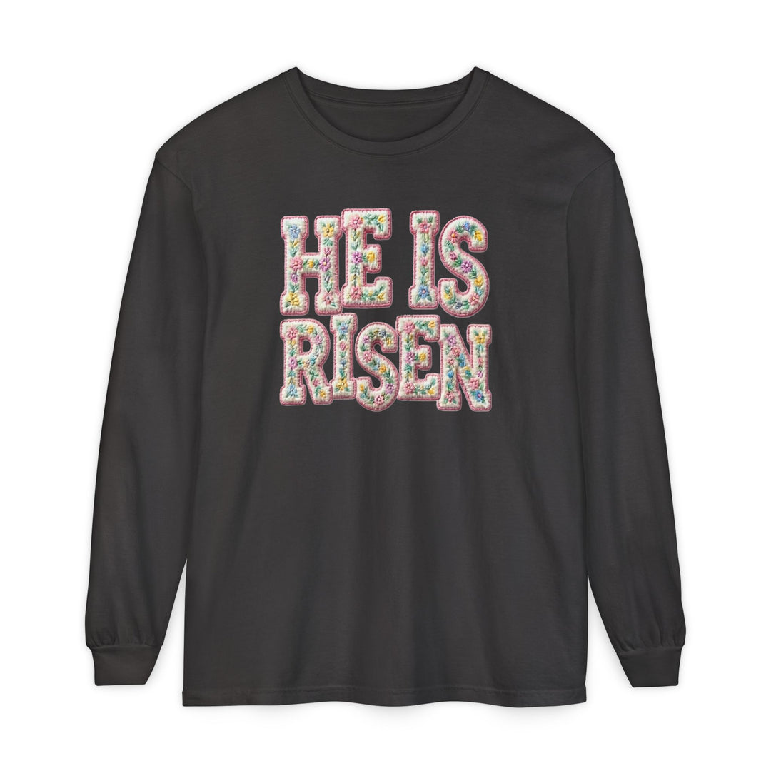 He is Risen Long Sleeve Tee with floral embroidery-style text on black, 100% ring-spun cotton, offering a relaxed, comfortable fit.