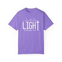 A ring-spun cotton Be the Light Tee, garment-dyed for extra coziness. Relaxed fit with double-needle stitching for durability and seamless design. From Worlds Worst Tees.