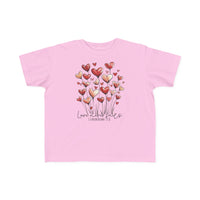 Light-pink toddler tee featuring whimsical heart graphics and Love never fails text, crafted from soft cotton for sensitive skin.