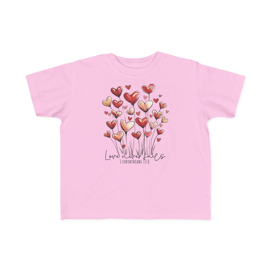 Light-pink toddler tee featuring whimsical heart graphics and Love never fails text, crafted from soft cotton for sensitive skin.