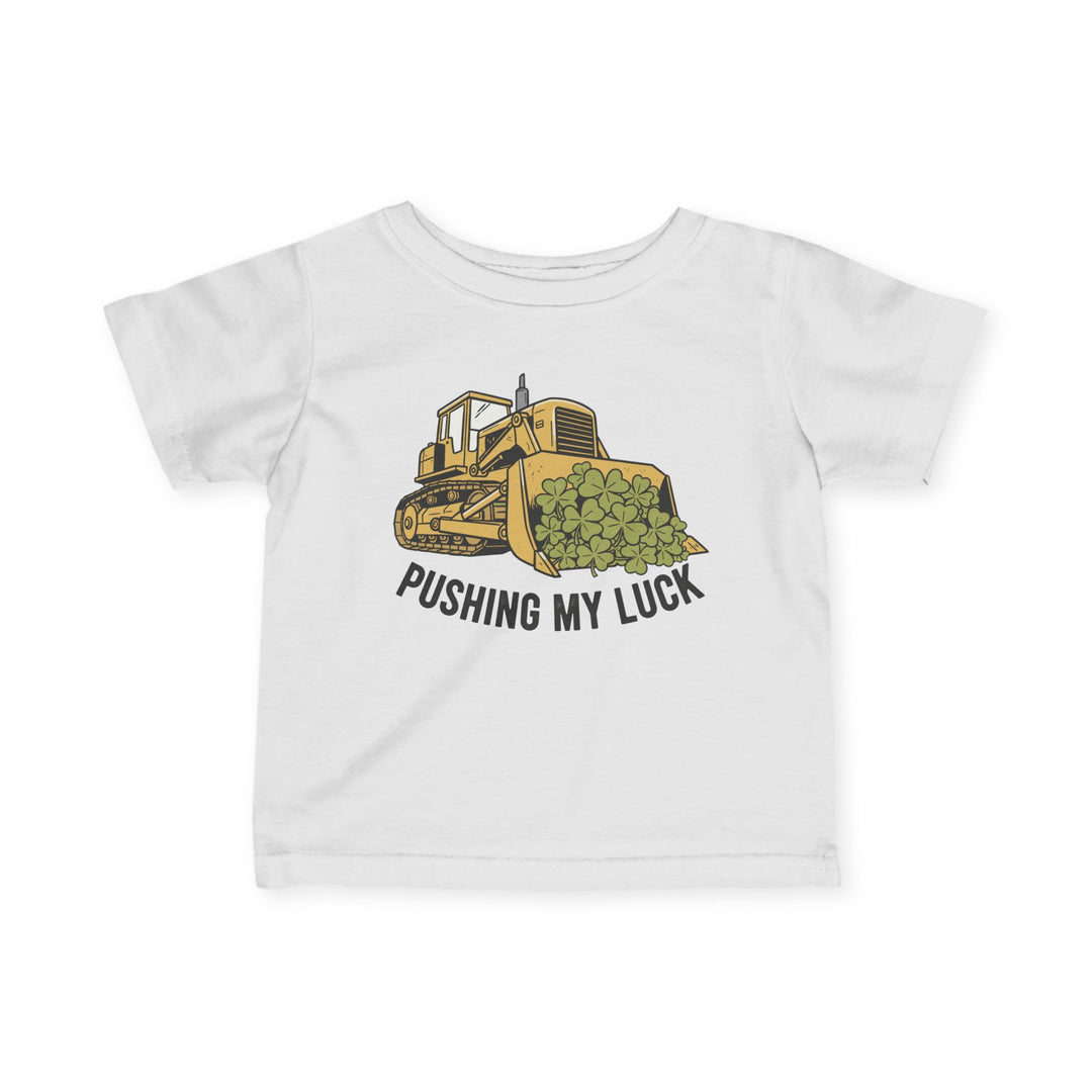 Pushing My Luck Baby Tee featuring a graphic of a yellow bulldozer with green clovers and slogan, designed for comfort and durability in toddler sizes.