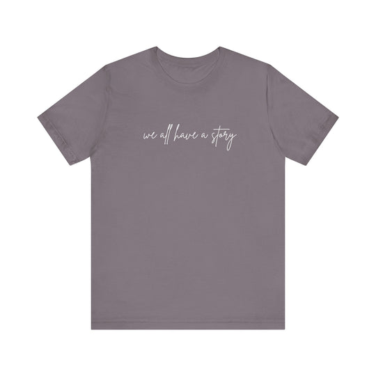 We all have a Story Tee: Grey t-shirt with white text, unisex fit, soft cotton, ribbed knit collar, and tapered shoulders for comfort and style.