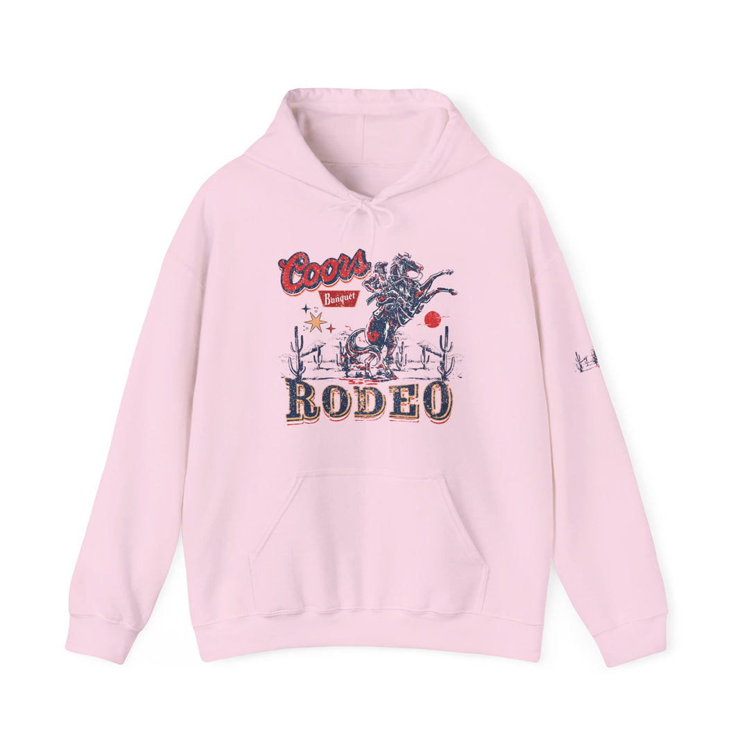 A Coors Rodeo Hoodie, a pink sweatshirt with a cowboy design. Unisex heavy blend, 50% cotton, 50% polyester, kangaroo pocket, drawstring hood, tear-away label. Classic fit, medium-heavy fabric.