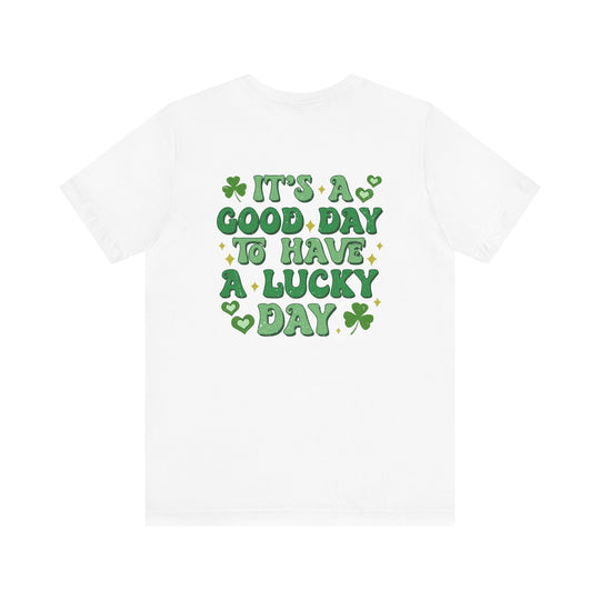 Good Day Lucky Day Tee: A classic white t-shirt featuring green text with hearts and clovers, crafted from soft cotton for a comfortable, unisex fit.