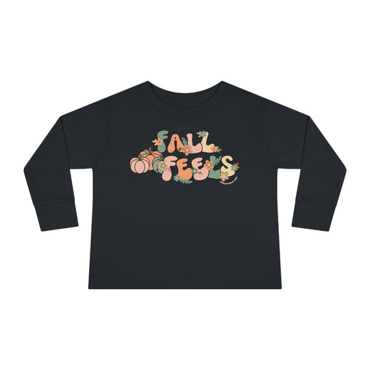 A durable Fall Feels Toddler Long Sleeve Tee made of 100% cotton, featuring a graphic design on a black shirt. Unisex fit with ribbed collar and EasyTear™ label for comfort and style.
