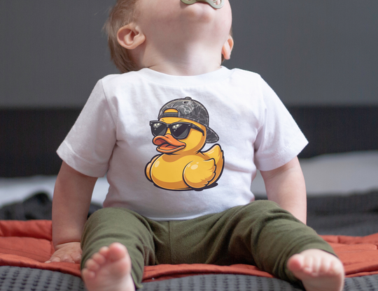 Baby wearing Ducky Baby Tee featuring a cartoon duck with sunglasses. The tee offers comfort with durable, 100% cotton fabric, perfect for active toddlers.