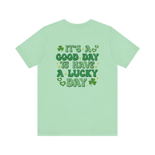 Good Day Lucky Day Tee featuring a green clover with gold stars, offering a classic unisex fit in soft cotton for enduring comfort and style.