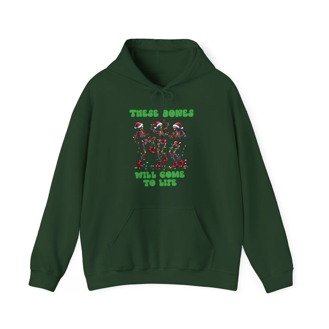 Dark-green hoodie with three dancing skeletons in Santa hats, wrapped in Christmas lights. Text reads THESE BONES WILL COME TO LIFE, referencing Ezekiel 37:1-5.