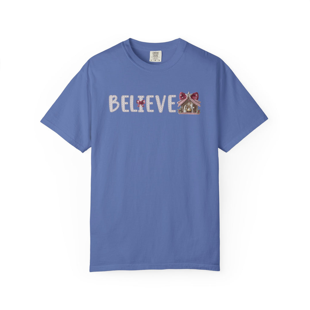 Believe Tee features festive 'BELIEVE' text with stitched letters and gingerbread house motif, perfect for cozy, stylish wear from Faith Family Designs.