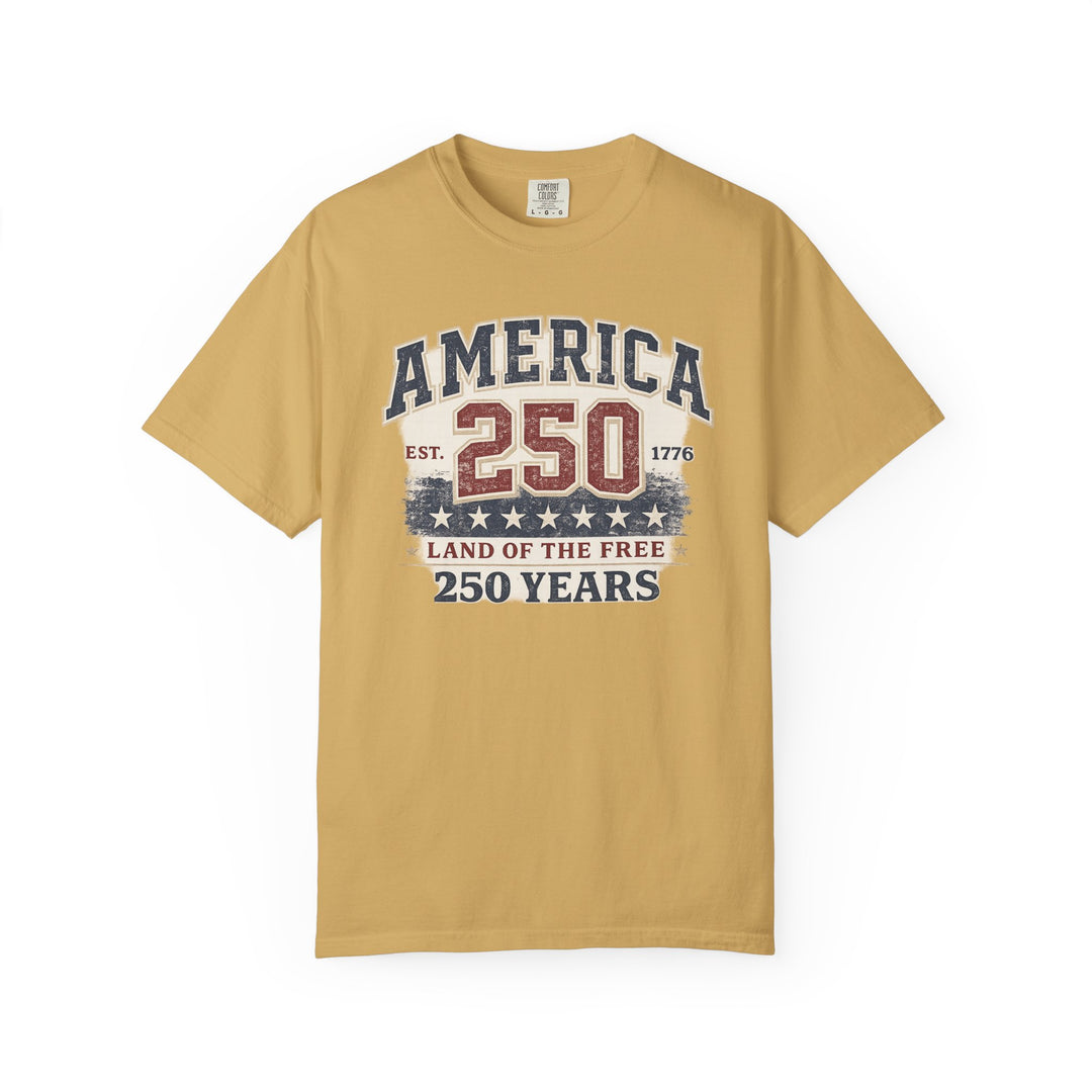 Mustard-yellow “America 250 Years Tee” featuring distressed patriotic graphics in red, white, and blue with stars, printed on a Comfort Colors cotton T-shirt, size L.