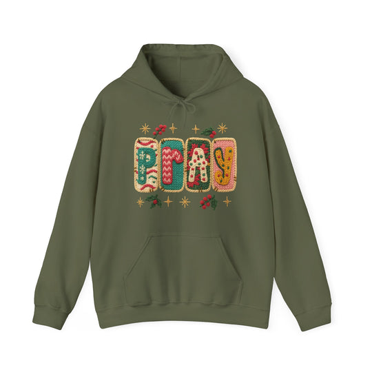 Olive-green PRAY hoodie with festive knit-style graphic, kangaroo pocket, and drawstring hood, blending comfort and style for cold days.