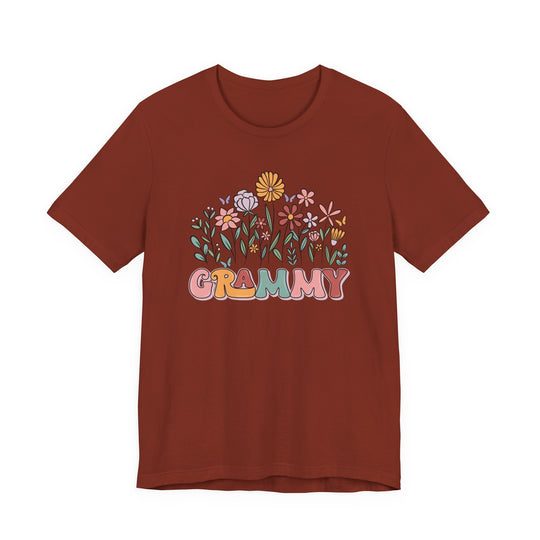 Rust-colored Grammy Flower Tee with pastel floral design and colorful GRAMMY text, short-sleeve, soft cotton, unisex fit, by Faith Family Designs.