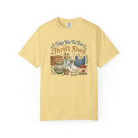 Pale-yellow Take Me To The Thrift Shop T-shirt with vintage-style graphic featuring thrift store treasures like a bread box, ceramic bowls, and decorative mushrooms.