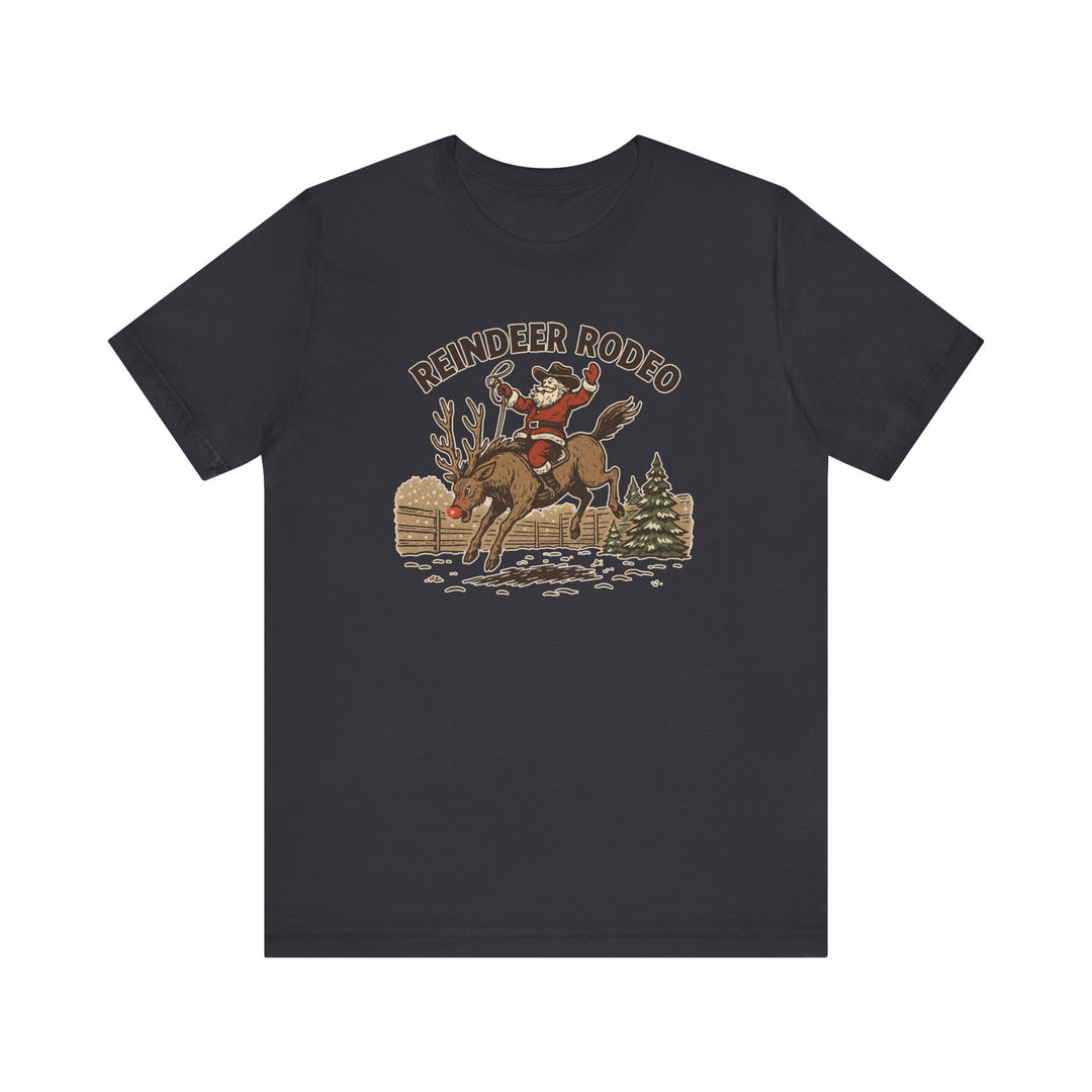 Reindeer Rodeo Tee features Santa in a cowboy hat riding a reindeer, printed on a soft, unisex charcoal crew-neck T-shirt, perfect for festive, western-themed style.