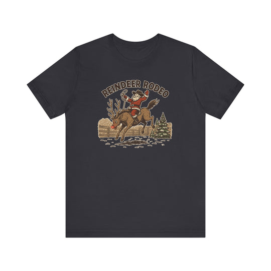 Reindeer Rodeo Tee features Santa in a cowboy hat riding a reindeer, printed on a soft, unisex charcoal crew-neck T-shirt, perfect for festive, western-themed style.