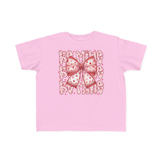 Be Mine Toddler Tee featuring a central ribbon-style bow with red hearts and BE MINE in heart-patterned letters, crafted for toddler comfort and durability.