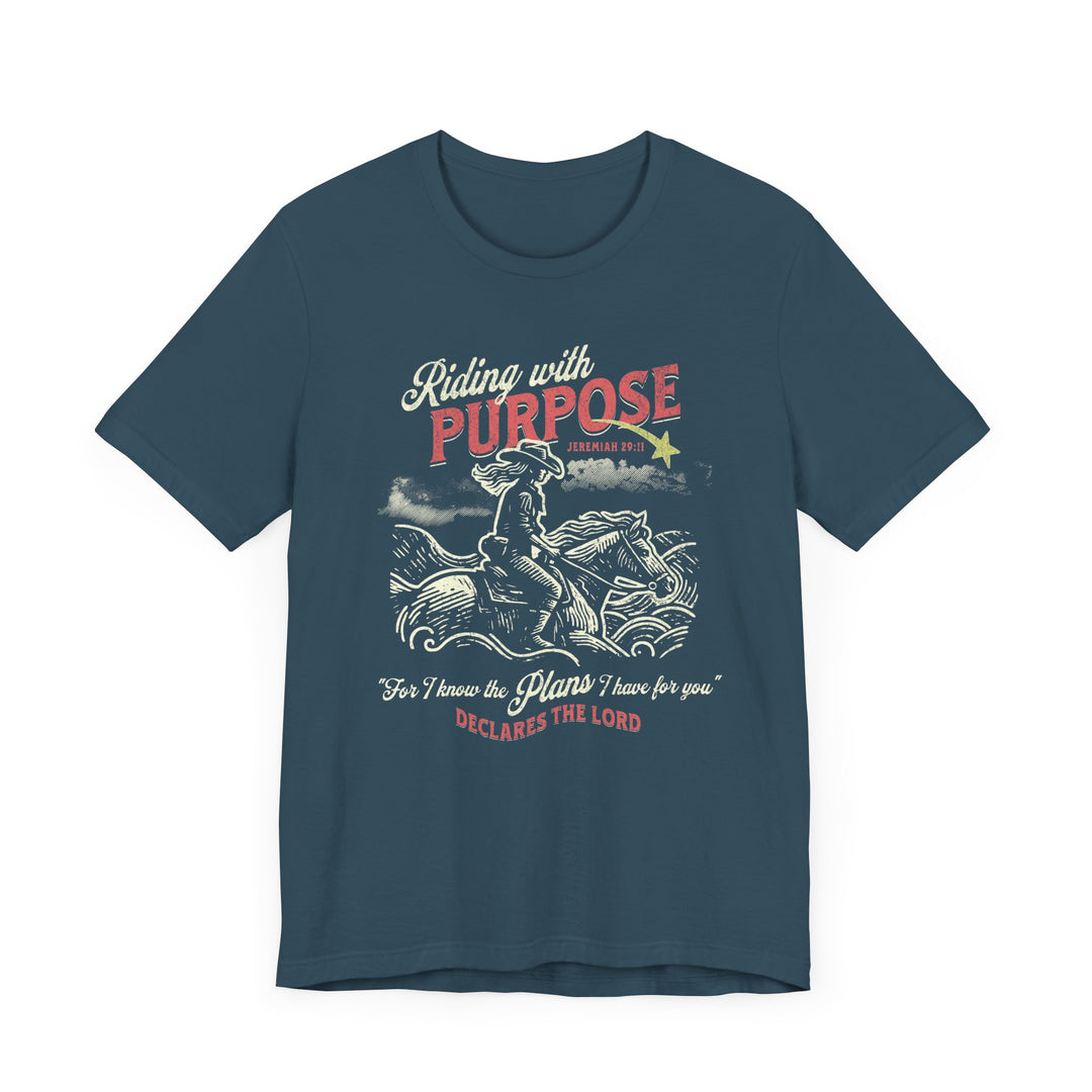 Riding for a Purpose Tee: Blue t-shirt featuring a graphic of a cowboy riding a horse, crafted from soft cotton with a comfortable retail fit.