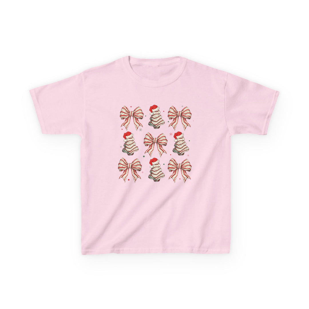 Cookies and Bows Kids Tee: Light-pink children's t-shirt featuring a 3x3 grid of red-and-white candy-cane bows and cookie-stacked Christmas trees with Santa hats.
