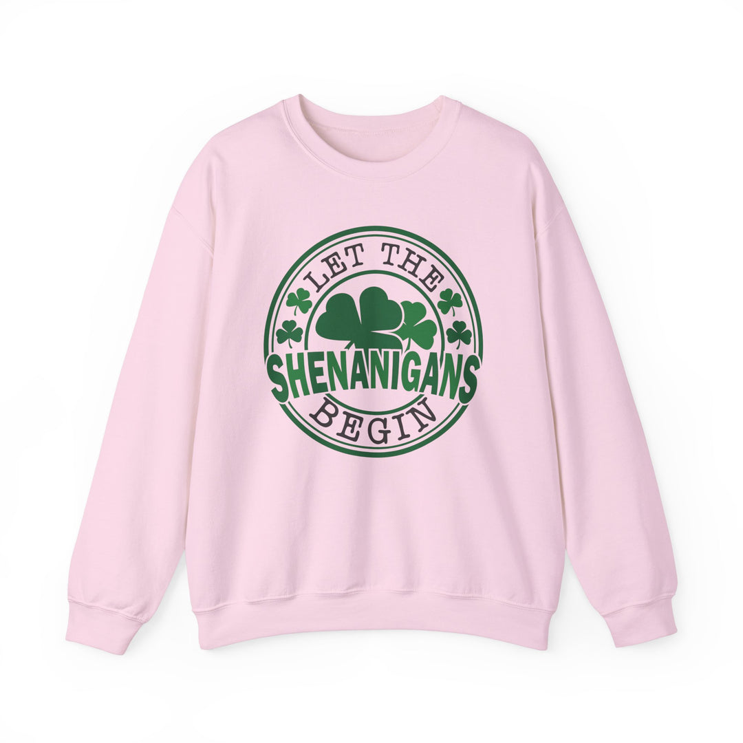 Let the Shenanigans Begin Day Crew sweatshirt featuring green text and clover logo on a pink background, ideal for casual comfort and style.