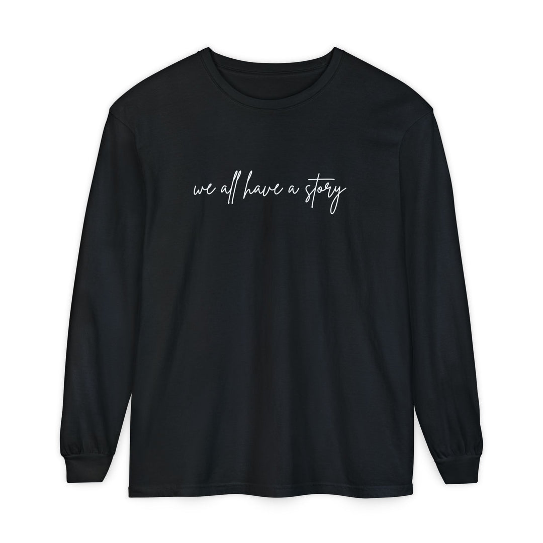 We All Have a Story Long Sleeve Tee, featuring white text on a black, 100% ring-spun cotton shirt with a relaxed fit.