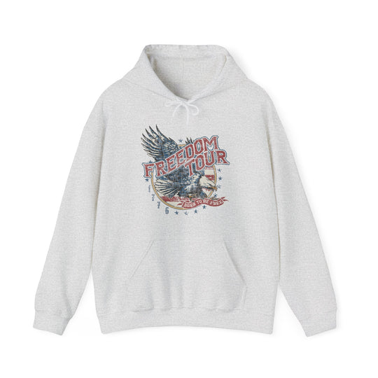 A white Freedom Tour Hoodie sweatshirt featuring a graphic eagle design. Unisex heavy blend fabric of cotton and polyester, with kangaroo pocket and drawstring hood. Medium-heavy, classic fit, tear-away label, true to size.