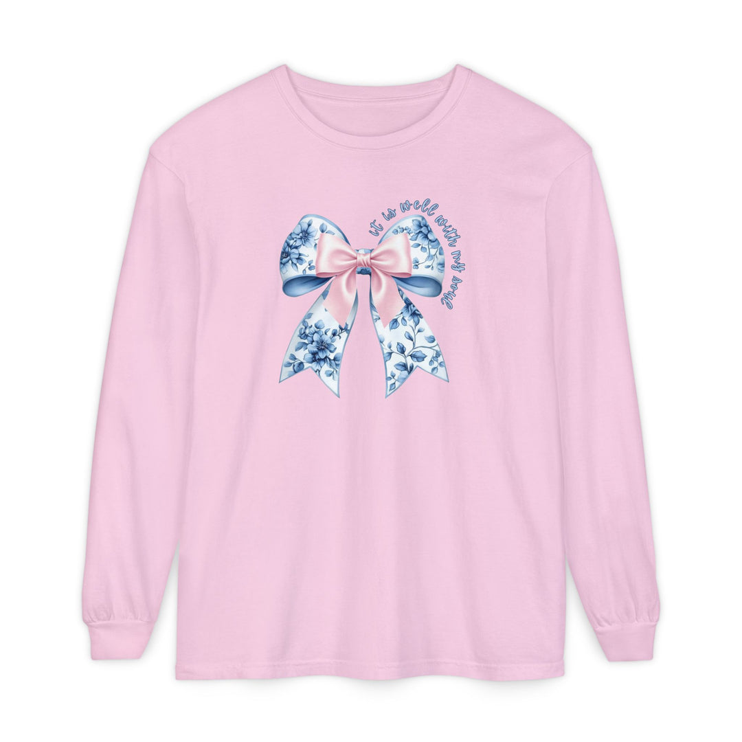 Light pink long-sleeve tee with a decorative bow and It is well with my soul in cursive, designed for comfort and style by Faith Family Designs.