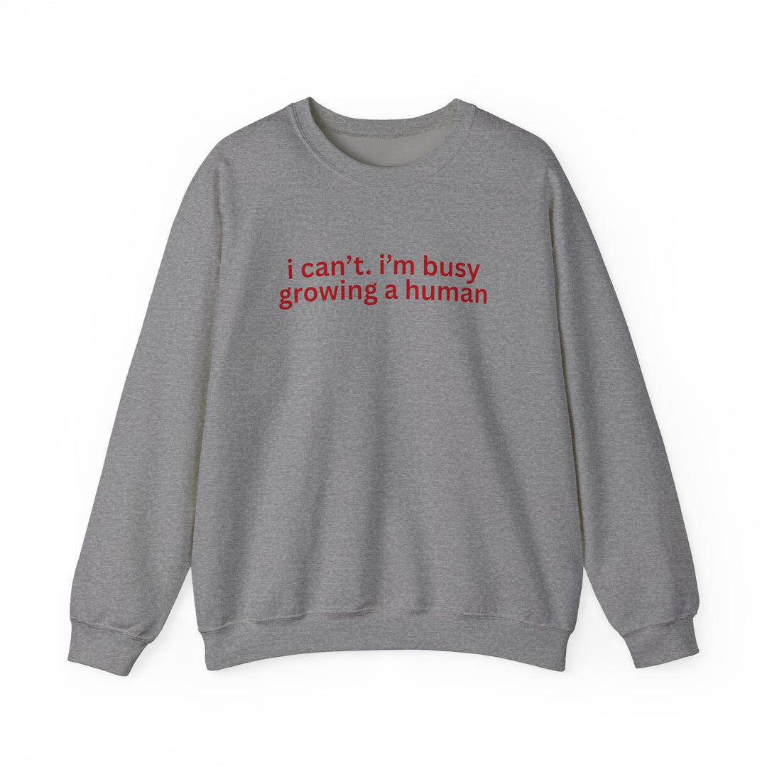 Heather-gray crewneck sweatshirt with bold red text, I can’t. i’m busy growing a human. Comfortable unisex fit from Faith Family Designs.
